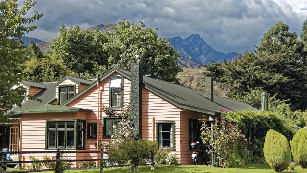 Weatherboard cottage with steep pitched roof and garden